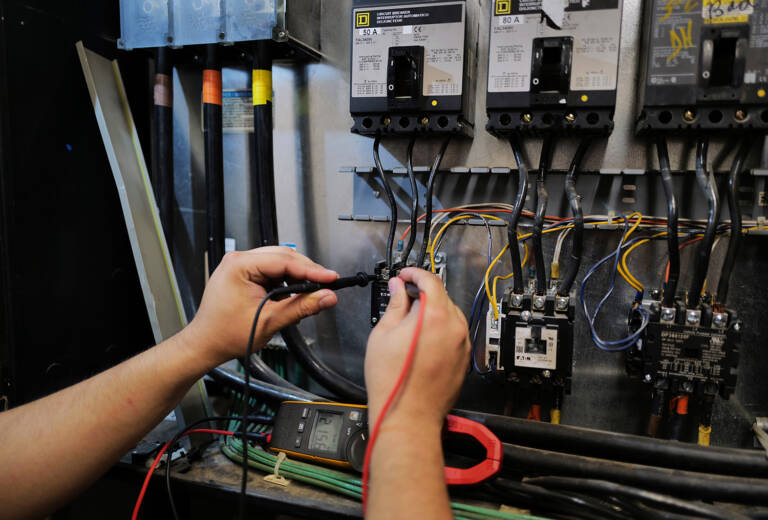 A technician working on a unit represents the hidden costs of emergency hvac downtime