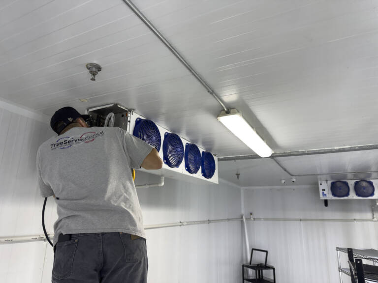 A TrueServ technician works on a commercial refrigeration installation