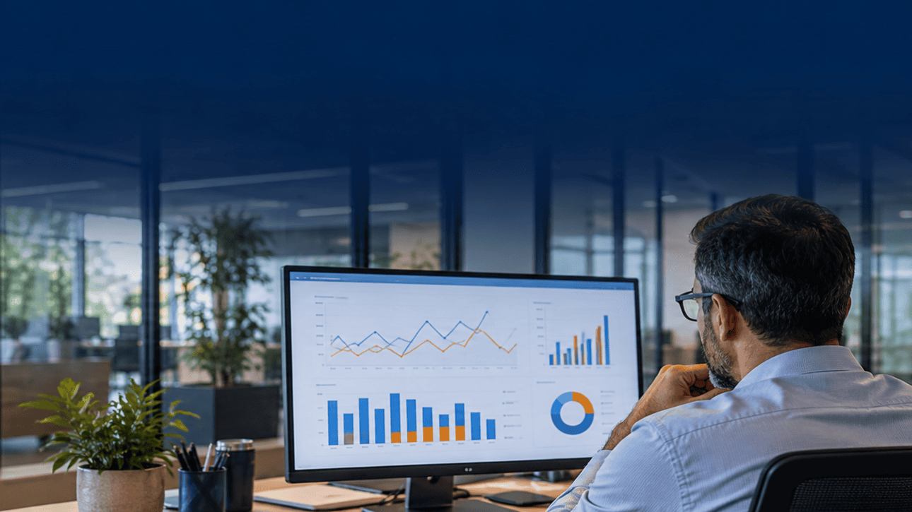 Facility manager reviewing building energy-use charts on a desktop monitor.