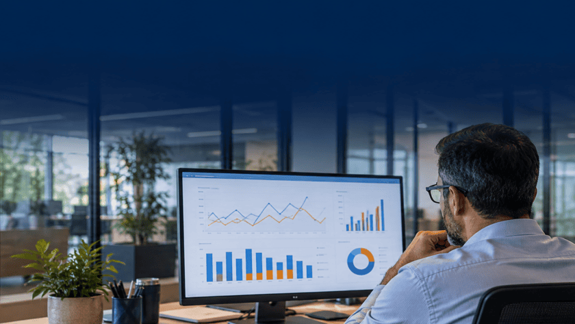 Facility manager reviewing building energy-use charts on a desktop monitor.